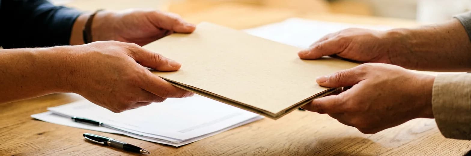 Submit a humanitarian project — handing over a proposal binder and checklist